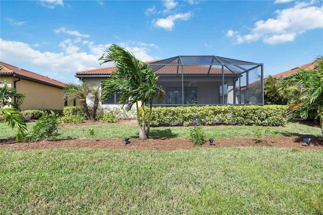 back of house with a lawn and glass enclosure