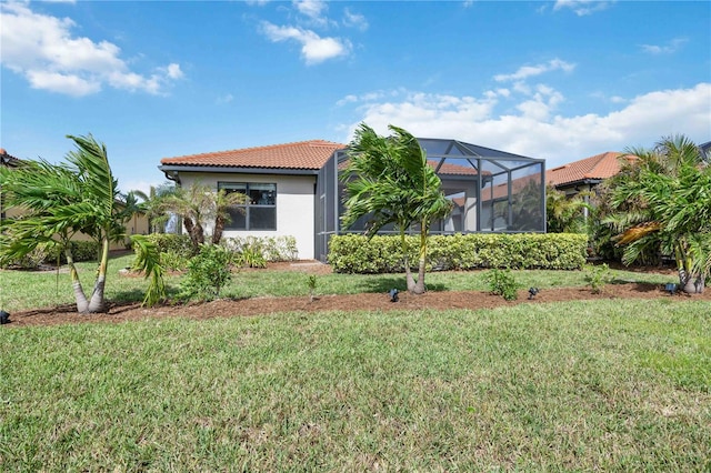 view of front of property with a front lawn and glass enclosure