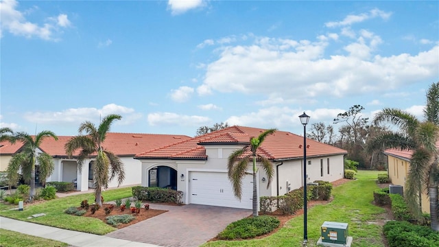 mediterranean / spanish-style home featuring a front lawn, a garage, and cooling unit