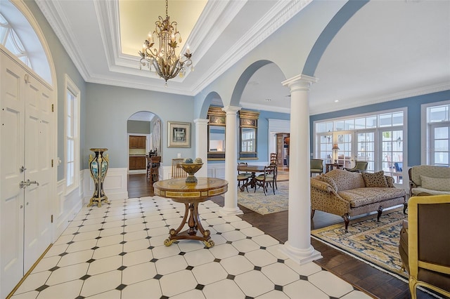 entrance foyer with a chandelier, crown molding, and light hardwood / wood-style floors