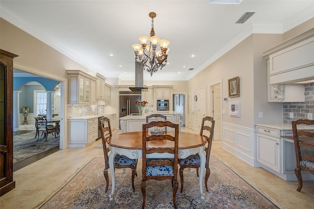 dining area with crown molding and an inviting chandelier