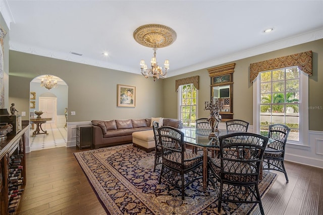 dining area with ornamental molding, a healthy amount of sunlight, and dark wood-type flooring