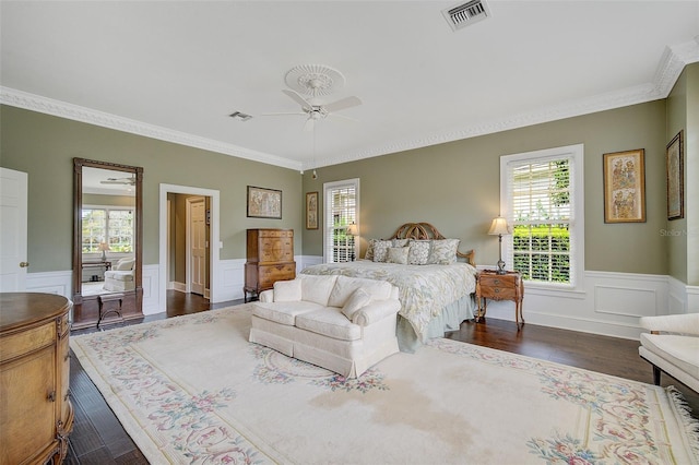 bedroom with dark hardwood / wood-style flooring, ornamental molding, and ceiling fan