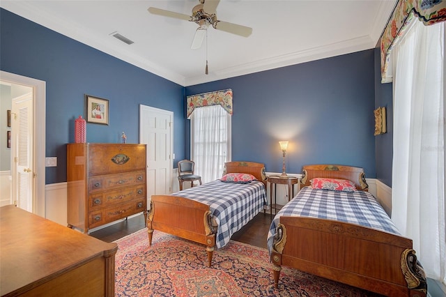 bedroom with dark hardwood / wood-style flooring, crown molding, and ceiling fan