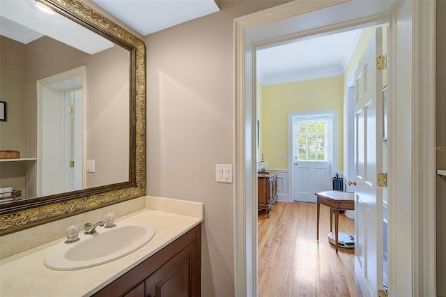 bathroom with vanity, ornamental molding, and hardwood / wood-style flooring