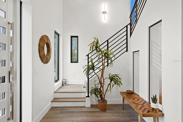 stairway with a high ceiling and hardwood / wood-style flooring