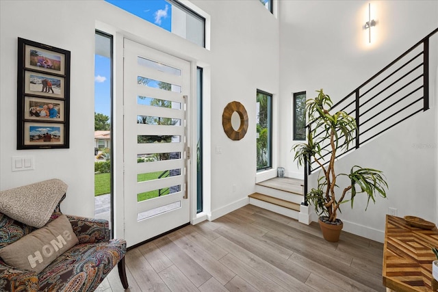 577 Venice Ln, Sarasota, FL 34242 - foyer featuring wood finished floors, stairway, baseboards, and a high ceiling