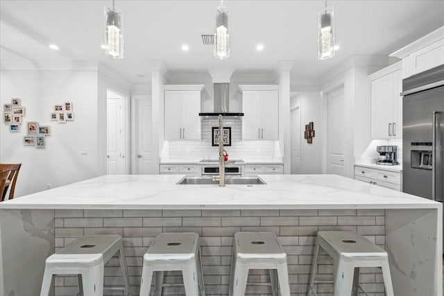 kitchen featuring stainless steel built in fridge, a breakfast bar, and hanging light fixtures