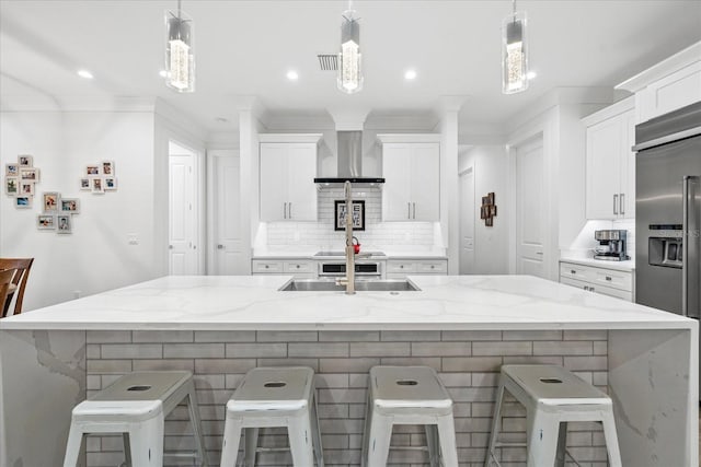 577 Venice Ln, Sarasota, FL 34242 - kitchen featuring built in refrigerator, backsplash, white cabinetry, wall chimney exhaust hood, and light stone countertops