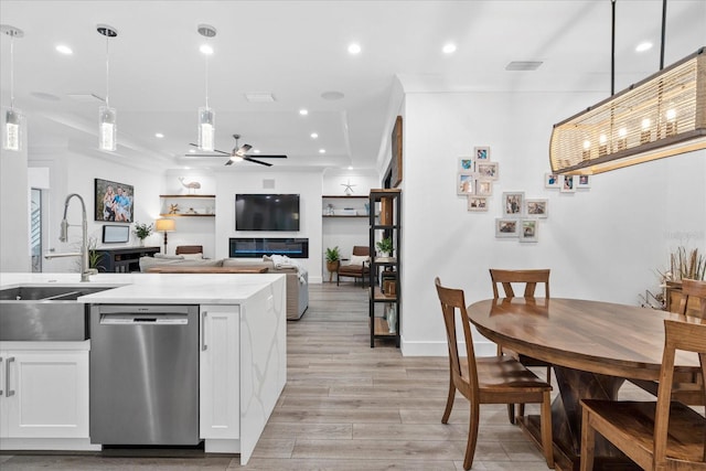 kitchen featuring stainless steel dishwasher, pendant lighting, white cabinets, ceiling fan, and sink