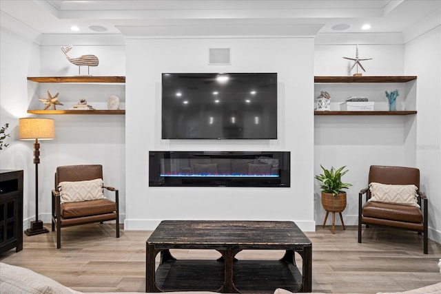 living room with light wood-type flooring and ornamental molding