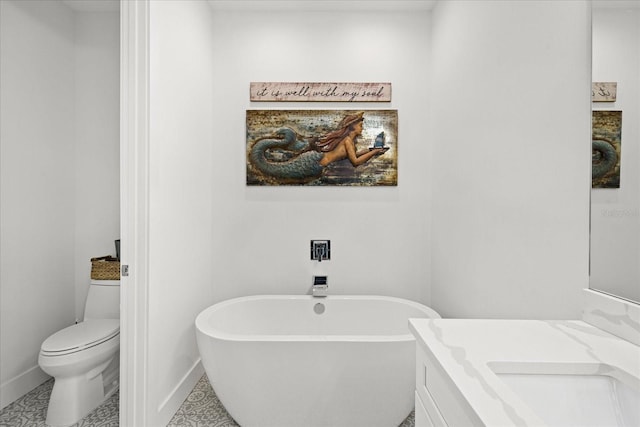 bathroom featuring toilet, vanity, tile patterned floors, and a bathtub