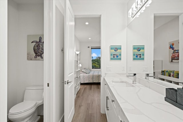 577 Venice Ln, Sarasota, FL 34242 - full bathroom with vanity, ensuite bath, toilet, wood finished floors, and recessed lighting