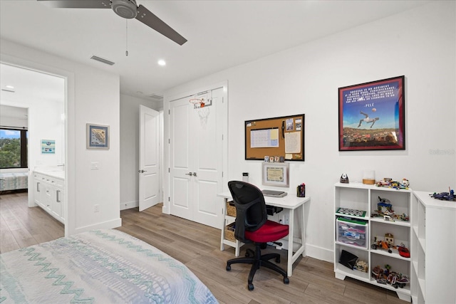 bedroom featuring ceiling fan, light hardwood / wood-style flooring, a closet, and connected bathroom