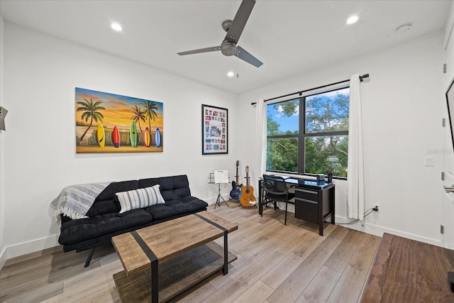 living room featuring ceiling fan and light hardwood / wood-style flooring