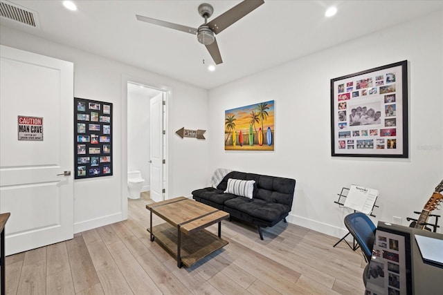 living room featuring ceiling fan and light hardwood / wood-style floors