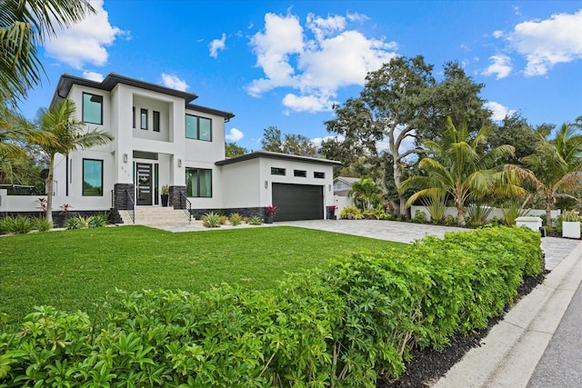 577 Venice Ln, Sarasota, FL 34242 - modern home featuring stucco siding, a front lawn, driveway, stone siding, and an attached garage