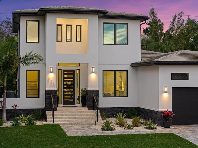 577 Venice Ln, Sarasota, FL 34242 - view of front of house featuring a garage, stucco siding, stone siding, driveway, and a tiled roof