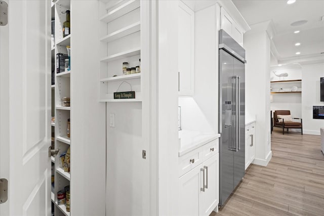 interior space with crown molding and light hardwood / wood-style flooring