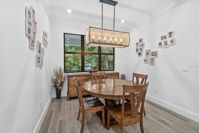 dining area featuring light hardwood / wood-style floors and crown molding