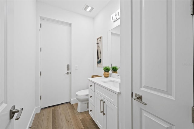 bathroom featuring hardwood / wood-style floors, vanity, and toilet