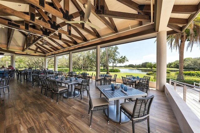 sunroom with a water view and vaulted ceiling with beams