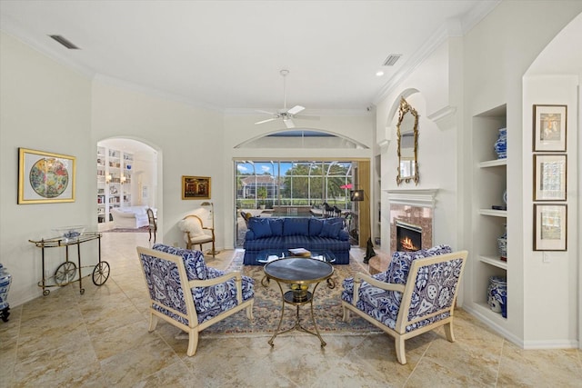 living room with built in features, ceiling fan, and crown molding