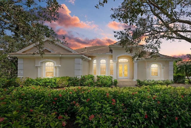 mediterranean / spanish house with french doors and stucco siding