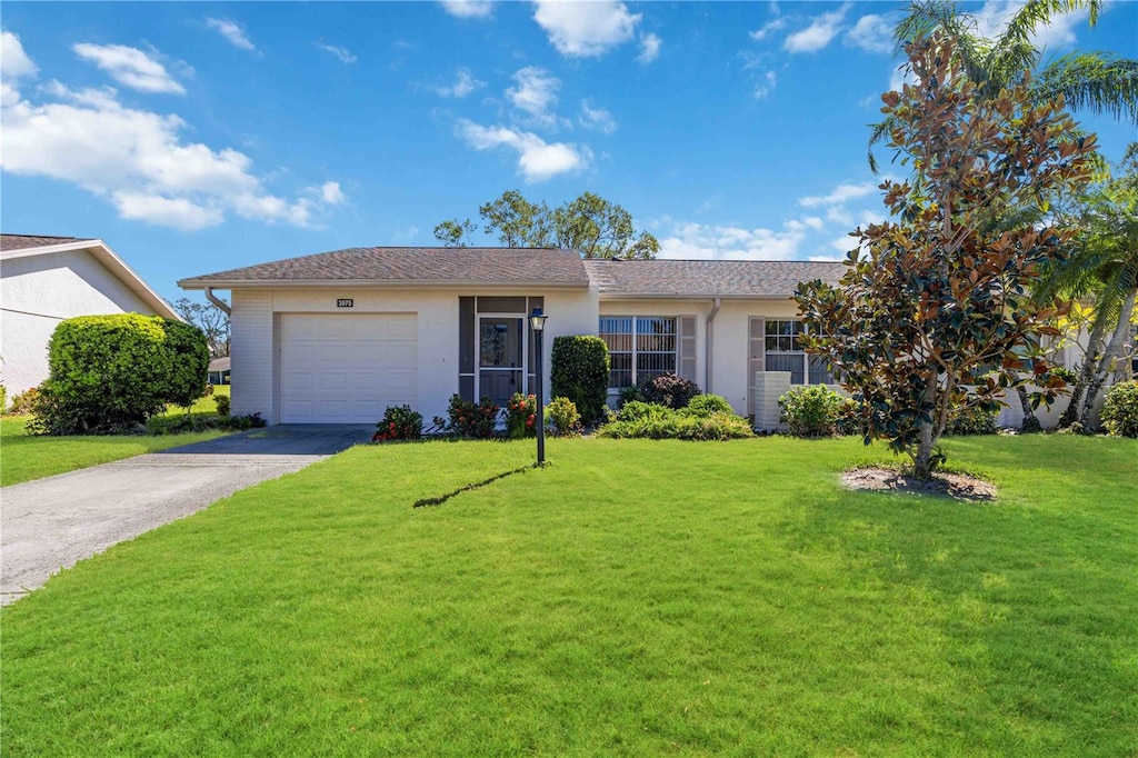 ranch-style house featuring a front lawn and a garage