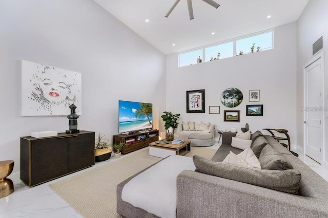 living room featuring a towering ceiling and ceiling fan