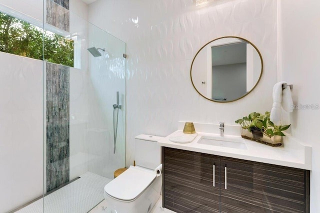 bathroom with vanity, a tile shower, and toilet