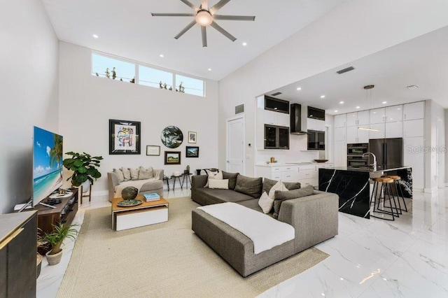 living room with a towering ceiling and ceiling fan