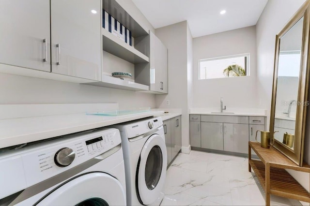 laundry area with sink, washing machine and dryer, and cabinets