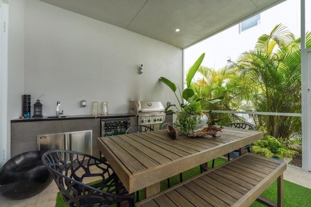 balcony with wine cooler, area for grilling, and an outdoor kitchen