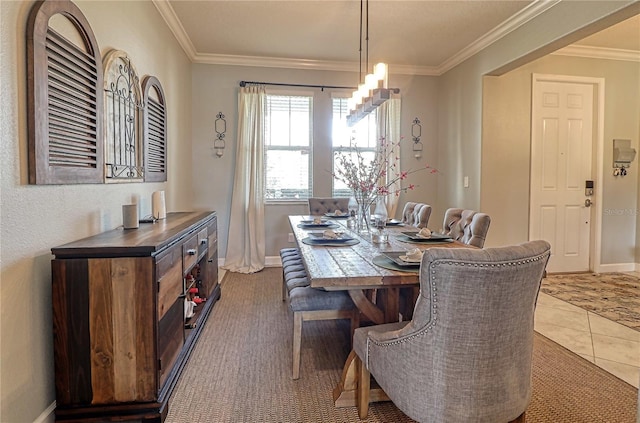 tiled dining room featuring crown molding and baseboards