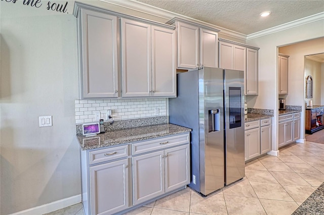 kitchen with light tile patterned floors, stone countertops, gray cabinets, stainless steel fridge with ice dispenser, and tasteful backsplash