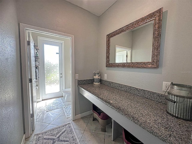 bathroom with baseboards, toilet, and tile patterned floors