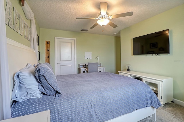 bedroom featuring a ceiling fan, light colored carpet, visible vents, and a textured ceiling