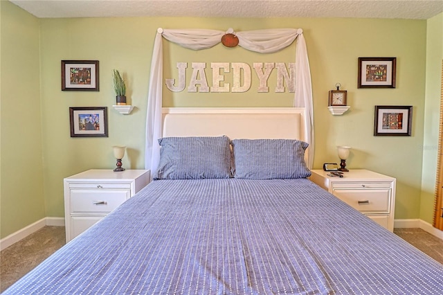 carpeted bedroom featuring a textured ceiling and baseboards