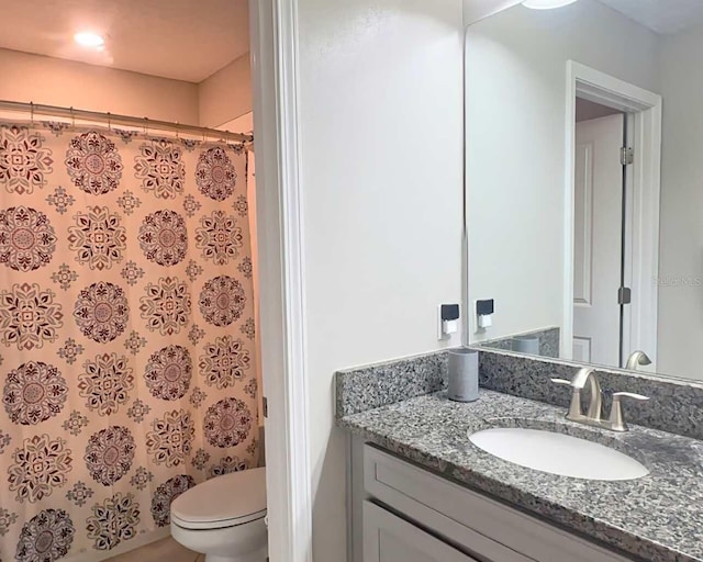 bathroom with a shower with shower curtain, vanity, and toilet