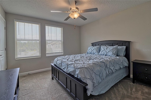 carpeted bedroom featuring ceiling fan, baseboards, and a textured ceiling