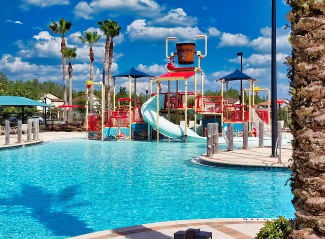 pool featuring playground community, a water slide, and a water play area