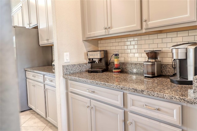 kitchen featuring light stone countertops, tasteful backsplash, and light tile patterned floors