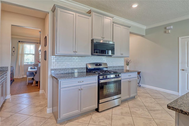 kitchen with light tile patterned floors, ornamental molding, stainless steel appliances, and decorative backsplash