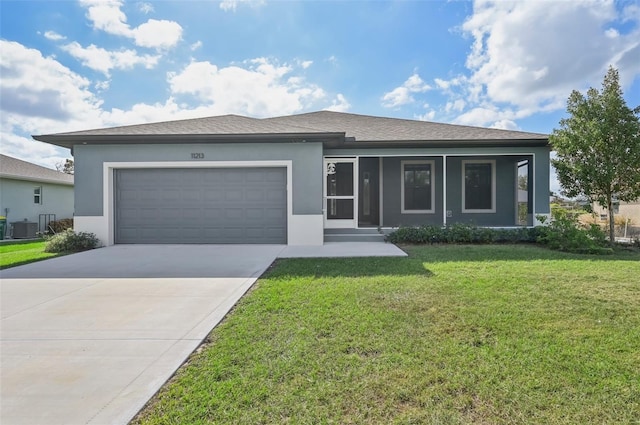 view of front of house with central AC unit, a garage, and a front lawn