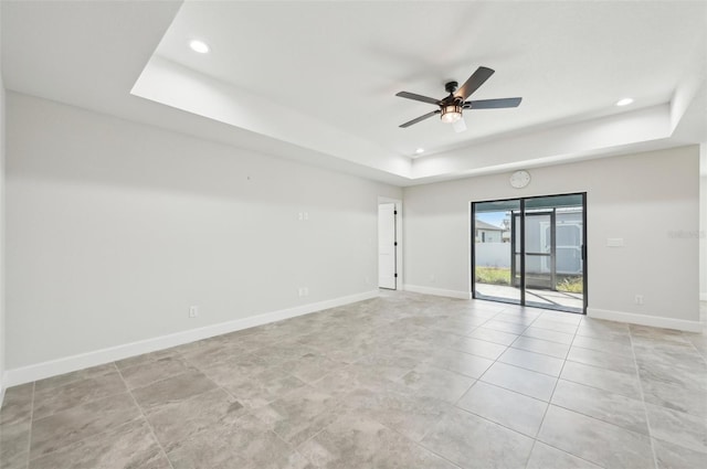 unfurnished room with a raised ceiling and ceiling fan