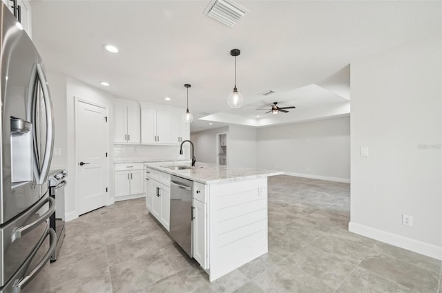 kitchen featuring light stone countertops, appliances with stainless steel finishes, a kitchen island with sink, sink, and white cabinetry