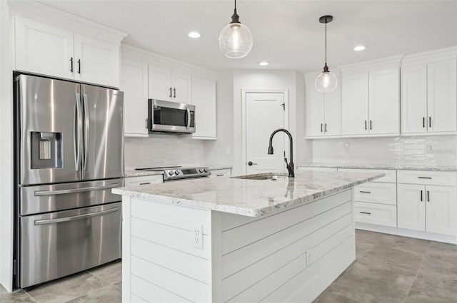 kitchen with a kitchen island with sink, white cabinetry, hanging light fixtures, and stainless steel appliances