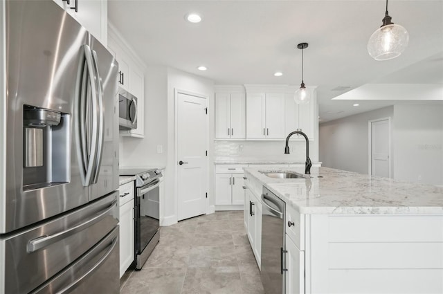 kitchen with white cabinets, pendant lighting, stainless steel appliances, and a kitchen island with sink