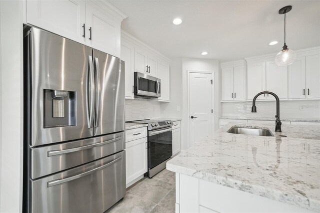 kitchen featuring sink, decorative light fixtures, decorative backsplash, white cabinets, and appliances with stainless steel finishes